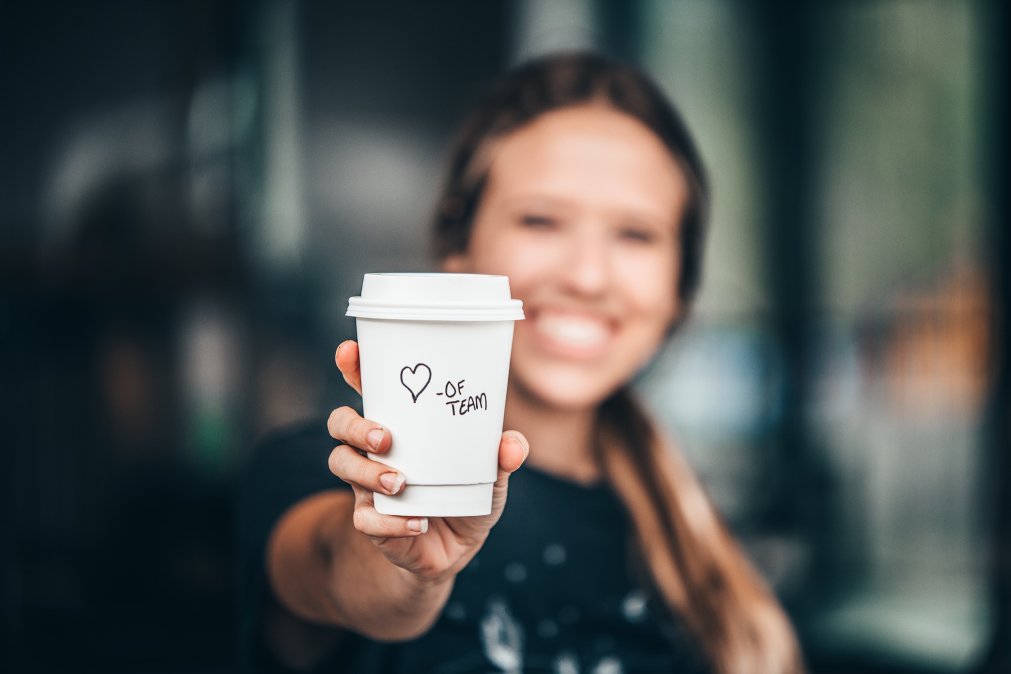 An OpenFlame team member offering a freshly prepared coffee